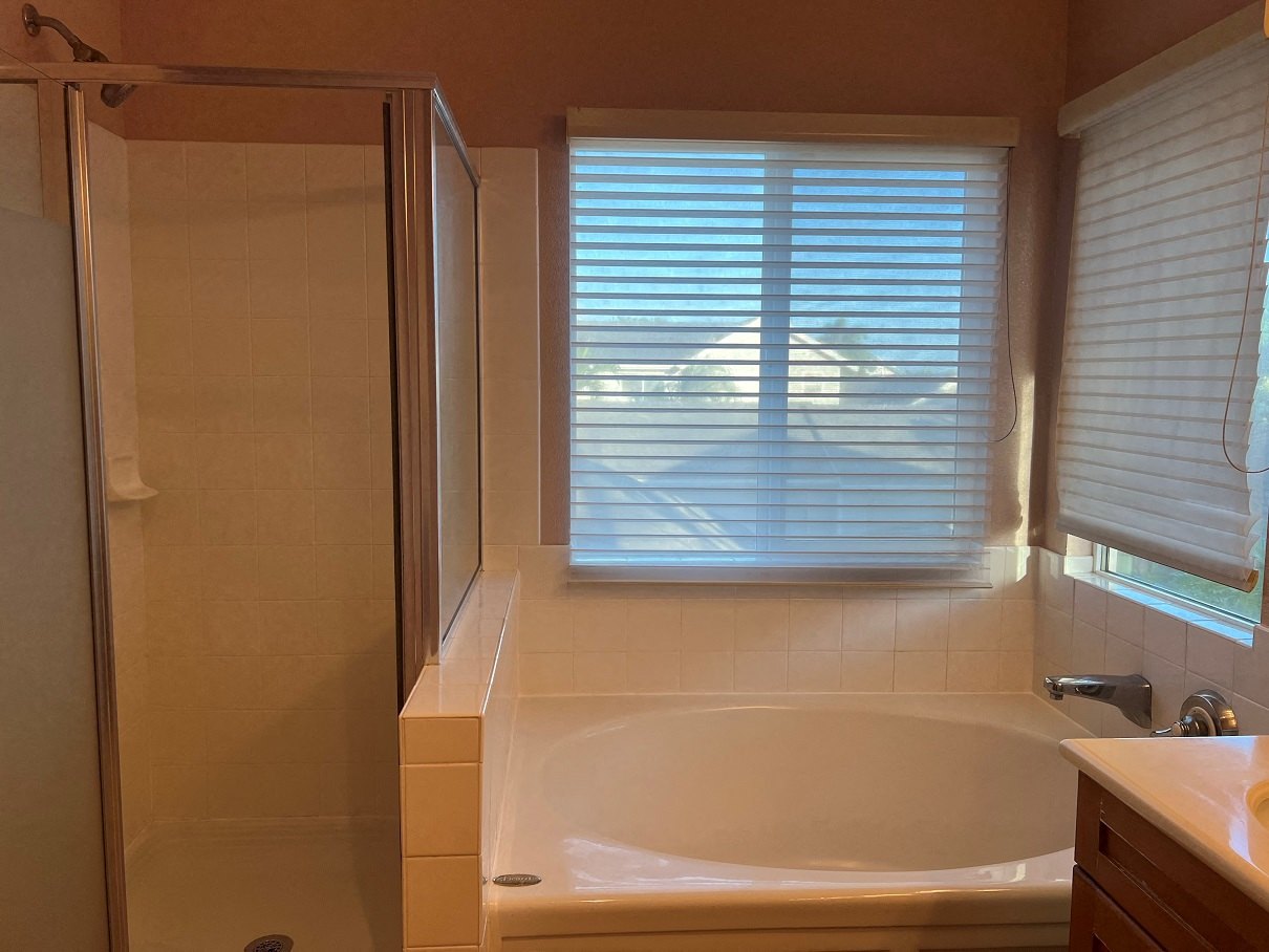 a bathroom with a tub and a shower and a window